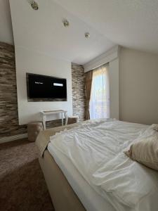 een slaapkamer met een groot bed en een flatscreen-tv bij Domilo in Mżyki