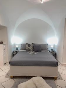 ein Schlafzimmer mit einem großen Bett mit zwei Lampen in der Unterkunft casa Alkamà in Castellammare di Stabia