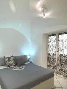 Schlafzimmer mit einem Bett und einem Fenster in der Unterkunft casa Alkamà in Castellammare di Stabia