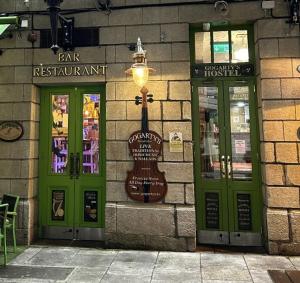 a building with green doors and a guitar on it at Gogartys Temple Bar Hostel in Dublin