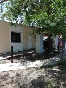 une maison avec un arbre en face dans l'établissement Cabañas Ezequiel, à Villa Carlos Paz