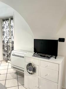 eine weiße Kommode mit einem TV darüber in der Unterkunft casa Alkamà in Castellammare di Stabia