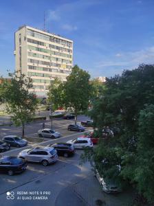 a parking lot with cars parked in front of a building at DiV 3 in Novi Sad