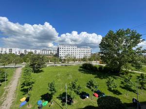 ein großer grüner Park mit Gebäuden im Hintergrund in der Unterkunft CozyApartment in Pristina