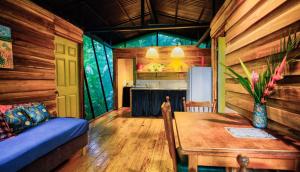 a living room with a table and a couch and a kitchen at La Shamana - Ecological Concept in Jungle in Cahuita