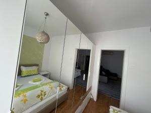 a bedroom with a mirror next to a bed at Апартаменти Уют in Plovdiv