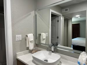 La salle de bains est pourvue d'un lavabo blanc et d'un miroir. dans l'établissement MainStay Suites, à Springfield