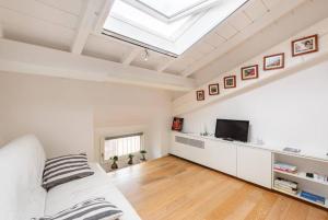 a room with a bed and a tv and a skylight at Residenza Palazzo Petrozzani in Mantova