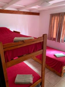 a bedroom with two bunk beds with red sheets at Camping El Bolson in El Bolsón