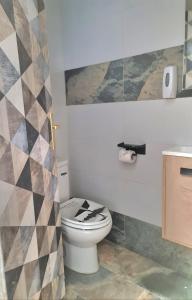 a bathroom with a toilet and a geometric wall at Loft con baño y cocina privados in San Sebastián de los Reyes