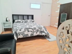 1 dormitorio con 1 cama en blanco y negro y 1 sofá en Loft con baño y cocina privados en San Sebastián de los Reyes