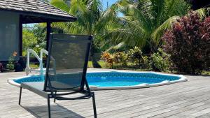 een stoel op een terras naast een zwembad bij RAIATEA - Orion Pool Bungalow in Uturoa