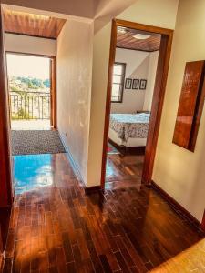 a room with a hallway with a bed and a mirror at Lar Loudge Montanhes in Campos do Jordão