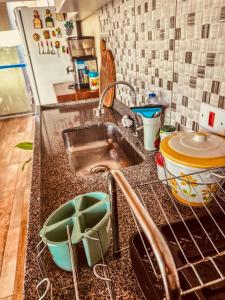 a kitchen counter with a sink in a kitchen at Lar Loudge Montanhes in Campos do Jordão