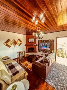 a living room with a couch and a tv at Lar Loudge Montanhes in Campos do Jordão