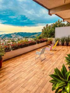 a balcony with chairs and a view of a city at Lar Loudge Montanhes in Campos do Jordão