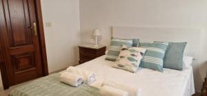 een slaapkamer met een bed met blauwe en witte kussens bij Apartamento Raxobrisamar in Raxo