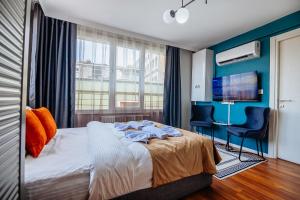 a bedroom with a bed and two chairs and a television at Taksim Wonder Suites in Istanbul