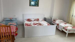 a bedroom with two beds and a table and chairs at Feriz Vukaj in Hamallë