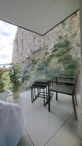 Habitación con mesa, banco y pared de roca. en 2BR apartment with Spa & Gym en Gibraltar