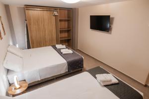 a hotel room with a bed and a tv at Amaryllis Maison Viziis in Alexandroupoli