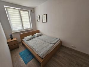 niewielka sypialnia z łóżkiem i oknem w obiekcie Luxury Green Kabaty Apartament nr 6 w Warszawie