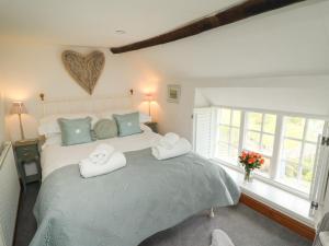 sypialnia z dużym łóżkiem z ręcznikami w obiekcie The Cottage w mieście Sandsend