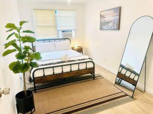 Dormitorio con cama con espejo y planta en Bungalow At Atlantic City Near The Waterpark Casinos en Atlantic City