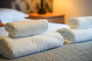 a stack of towels sitting on top of a bed at Rider Gardens Holiday House in Boston