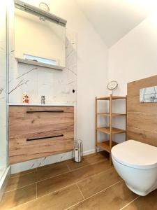 uma casa de banho com um WC branco e um lavatório. em Dom Wakacyjny Klifowa 1 em Mechelinki