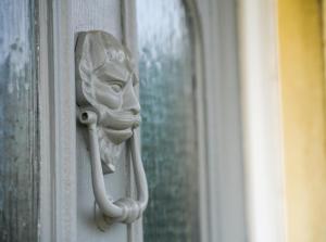 a statue of a face on a door at Rider Gardens Holiday House in Boston