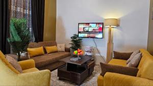 a living room with two couches and a tv at شقة مكيفة مفروشة بالكامل فرش جديد بالمنصورة in Mansoura