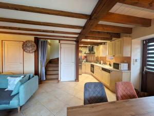 un soggiorno con un divano blu e una cucina di Nature et piscine privée - Maison 5 chambres 8 personnes a Saint-Dolay