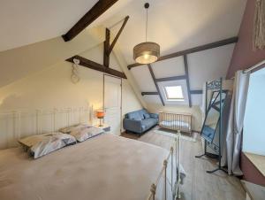 una camera da letto con un letto grande in una mansarda di Nature et piscine privée - Maison 5 chambres 8 personnes a Saint-Dolay Altre 15 foto