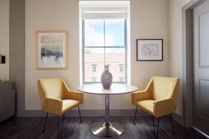 a vase sitting on a table in a room with two chairs at Kasa Altmayer Savannah in Savannah