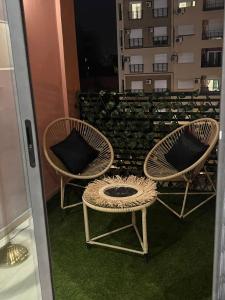 two wicker chairs and a table on a balcony at appartement en pleine centre gueliz en face théâtre royal in Marrakesh