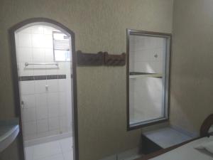 a bathroom with a mirror and a shower at Motel Onix in Belo Horizonte