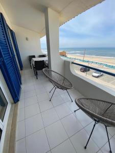 a balcony with chairs and a view of the beach at Apartamento frente mar in Praia da Vieira