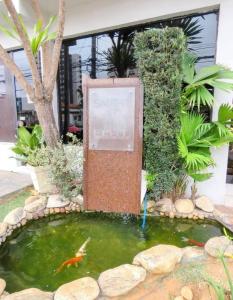 a koi pond with a sign in front of a building at LEON MARIA HOSPEDAGENS - Smart Flat Hotel e Residence in Mogi das Cruzes
