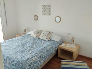 a bedroom with a bed with a blue comforter at Apartamento Terraza Mar El Azul in Santa Susanna