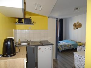 a kitchen with a sink and a room with a bed at Le Notre Dame in Boulogne-sur-Mer