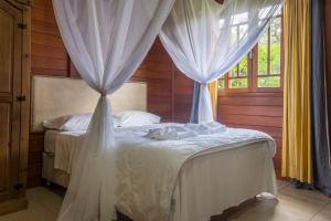 1 dormitorio con 2 camas con cortinas blancas en Fazenda dos Caetés, en Camboriú