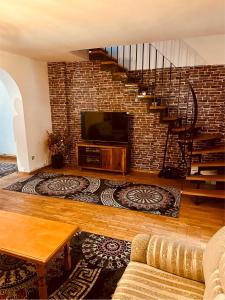 a living room with a tv and a brick wall at House in Center in Skopje