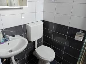 a bathroom with a white toilet and a sink at Apartman Peace 3 in Međugorje