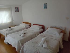 a room with three beds with towels on them at Apartman Peace 3 in Međugorje