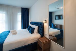 una camera d'albergo con letto e specchio di ALIVE HOTEL a Oradea