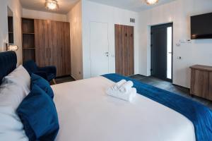 1 dormitorio con 1 cama blanca grande y 2 toallas en ALIVE HOTEL, en Oradea