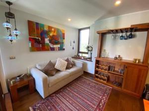 a living room with a couch and a rug at Dpto Pucon - Pinares 2D 2B in Pucón