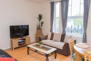 a living room with a couch and a tv at Birmingham City Apartment - Spacious & Fully Serviced with Secure Parking in Birmingham