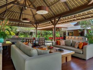 an outdoor living room with couches and a table at Villa Asta in Seminyak